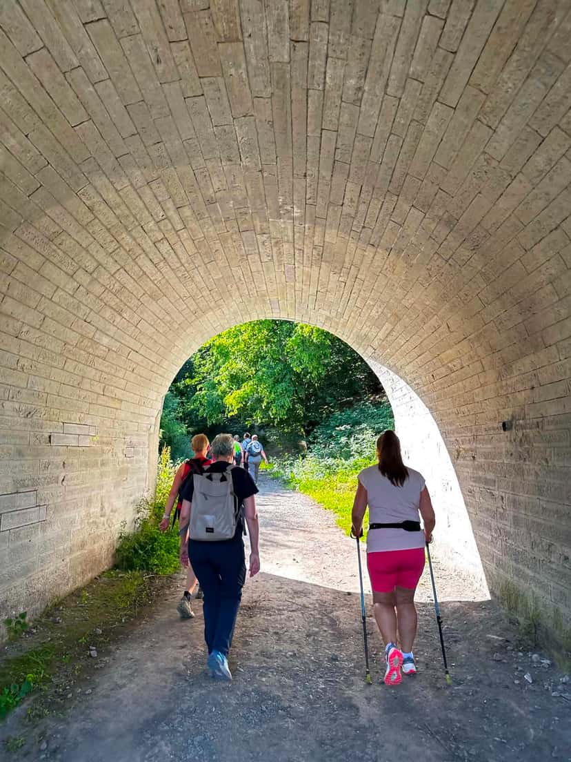 Passage sous un tunnel de briques, bâtons à la main