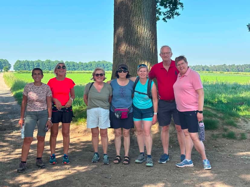 Photo de groupe au pied d'un grand arbre, en bordure de champ