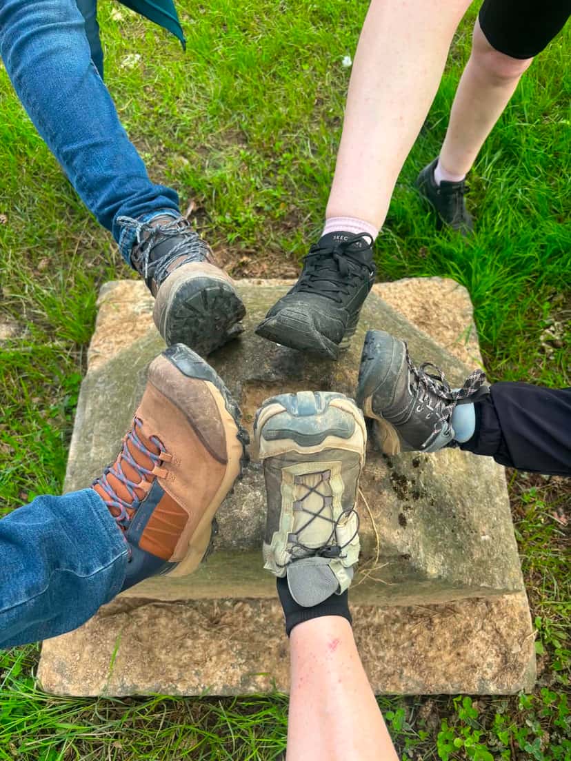 Les chaussures du groupe réunies en étoile sur une borne de pierre