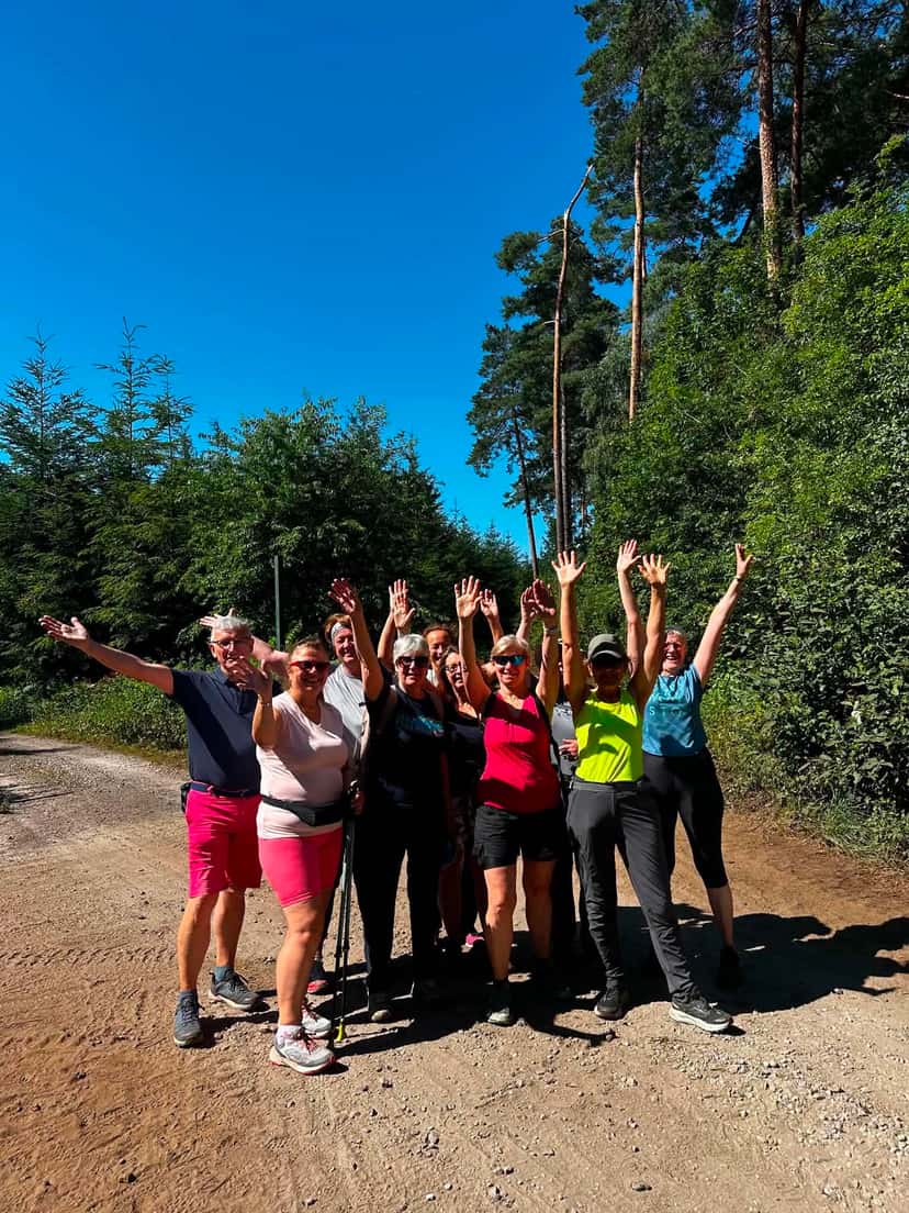 Éclats de rire et bras levés au milieu du chemin forestier